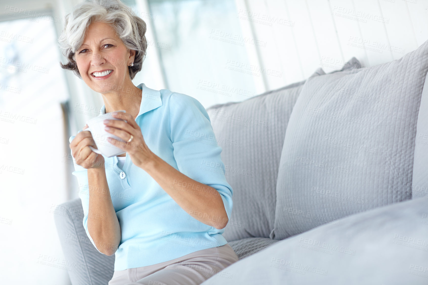 Buy stock photo Senior woman, portrait and coffee on sofa to relax, satisfaction and confident for peace or calm. Female person, drinking tea and smile in retirement, wellness and happy in apartment for good mood 