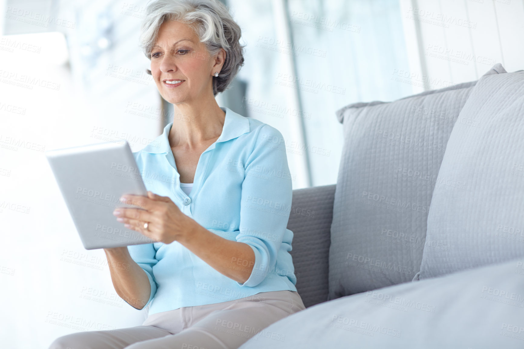 Buy stock photo Senior woman, tablet and happy on sofa in home, living room and reading ebook to relax in retirement. Mature person, digital touchscreen and smile with app, newsletter and email notification in house