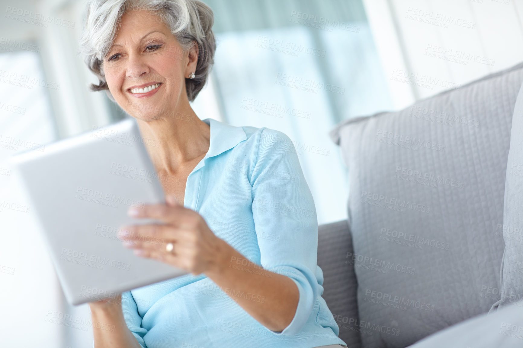 Buy stock photo Senior woman, tablet and smile on sofa in home, living room and reading ebook to relax in retirement. Mature person, digital touchscreen and happy with app, newsletter and email notification in house