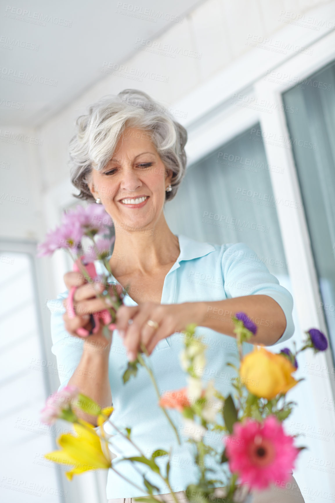 Buy stock photo Senior, woman and happy to arrange flowers in home, vase and creativity in spring of retirement. Floral, bouquet and elderly person with gardening hobby or relax with daisy wildflowers in house