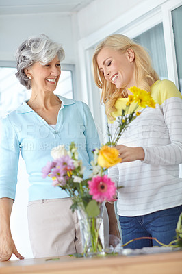 Buy stock photo Flowers, mom and happy woman in home to relax together with smile, love and wellness for affection. Mothers day, mature and daughter bonding in lounge with family, parent and gift present in Germany