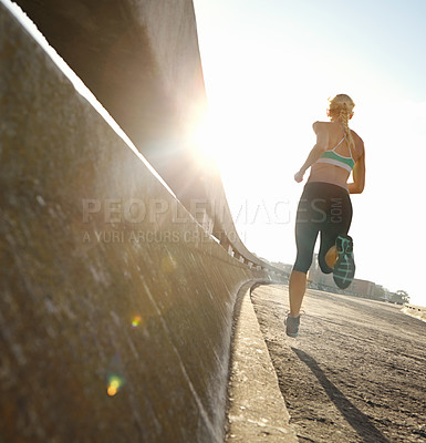 Buy stock photo Rear view shot of a young woman on her morning run
