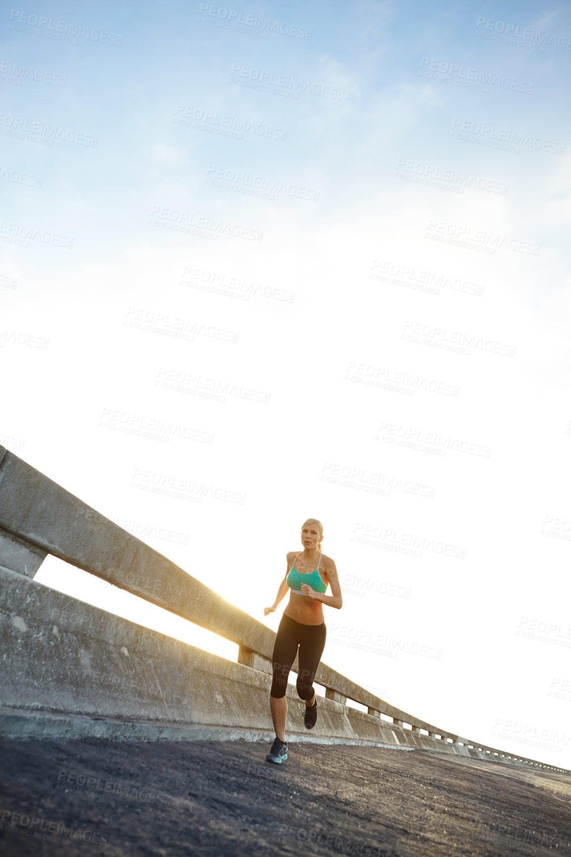 Buy stock photo Blue sky, fitness and woman with running in road for cardio, training and exercise for marathon. Athlete, street and runner with outdoor workout for sports, energy and muscle health in Denmark