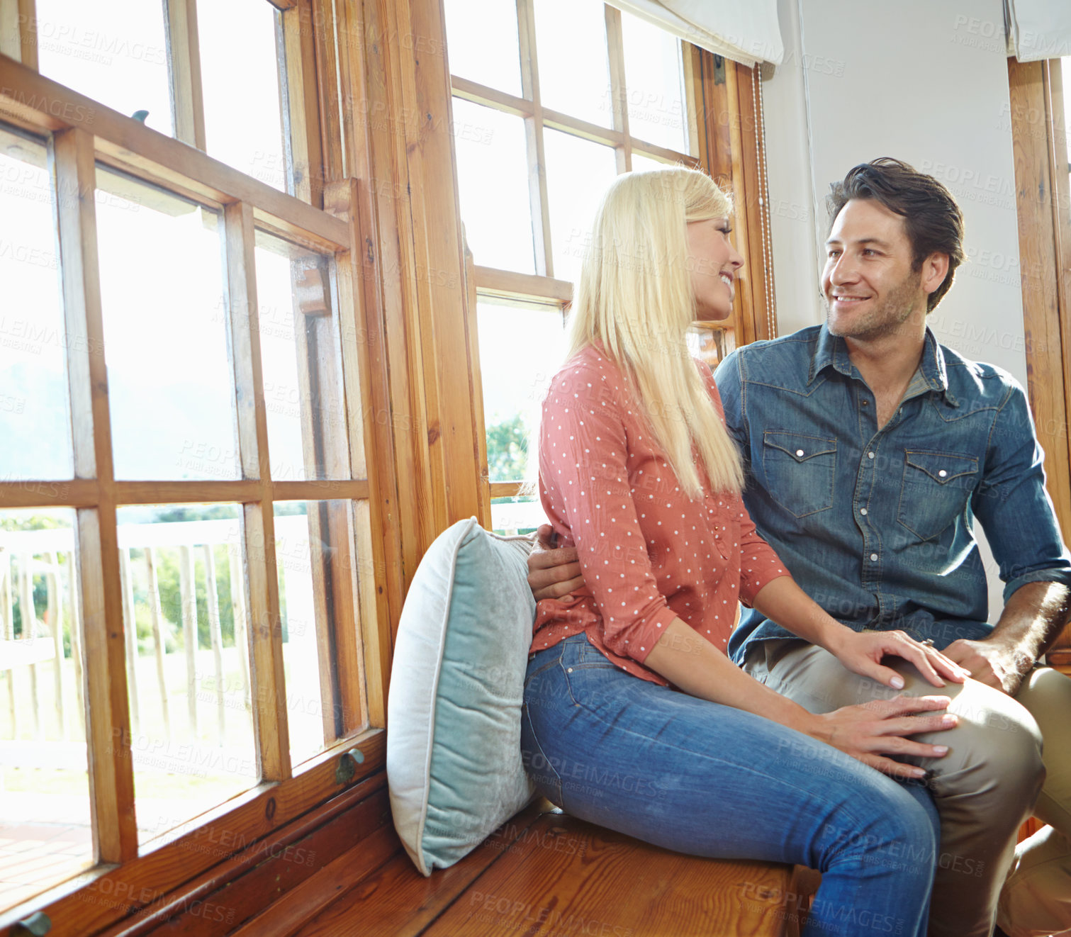 Buy stock photo Couple, happiness and relax on window bench for bonding in living room, smile or hug in new apartment together. Home, happy and commitment for support, romantic or relationship for security with love