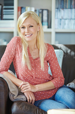 Buy stock photo Portrait of a caucasian woman sitting on a comfortable leather sofa in her office at home. A beautiful young smiling blonde lady relaxing in the living room of her house. Cheerful female resting alone