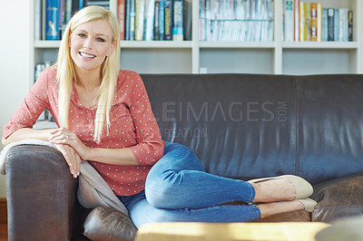 Buy stock photo Portrait of on young blonde woman relaxing at home on the sofa in the lounge. Cheerful female sitting on the couch in the living room alone on the weekend. Comfy, smiling and resting in a room inside