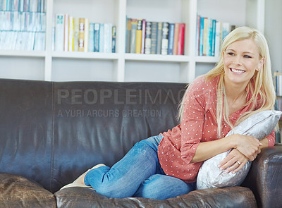 Buy stock photo One young blonde woman relaxing at home on the sofa and looking thoughtful. Cheerful female sitting on the couch in the living room alone and thinking. Comfy, smiling and resting in the living room