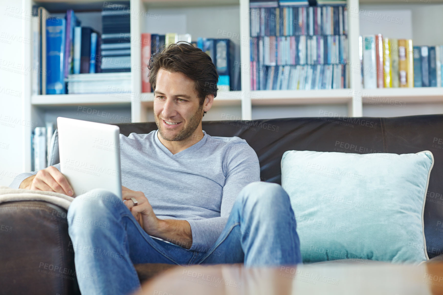 Buy stock photo Man, relax and smile on sofa with tablet for internet streaming, online gaming and social media in living room of home. Person, happy and digital tech for reading ebook, web search or browse on couch