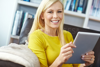 Buy stock photo Portrait of a woman using a tablet while sitting on a sofa. Happy young female watching and browsing online on her touchscreen device with wireless wifi connection, enjoying a casual weekend at home