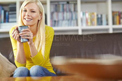 Buy stock photo Portrait one beautiful woman sitting alone on the sofa in her living room, smiling and drinking coffee. Young woman feeling happy while enjoying a cup of tea. Relaxing on the couch over the weekend