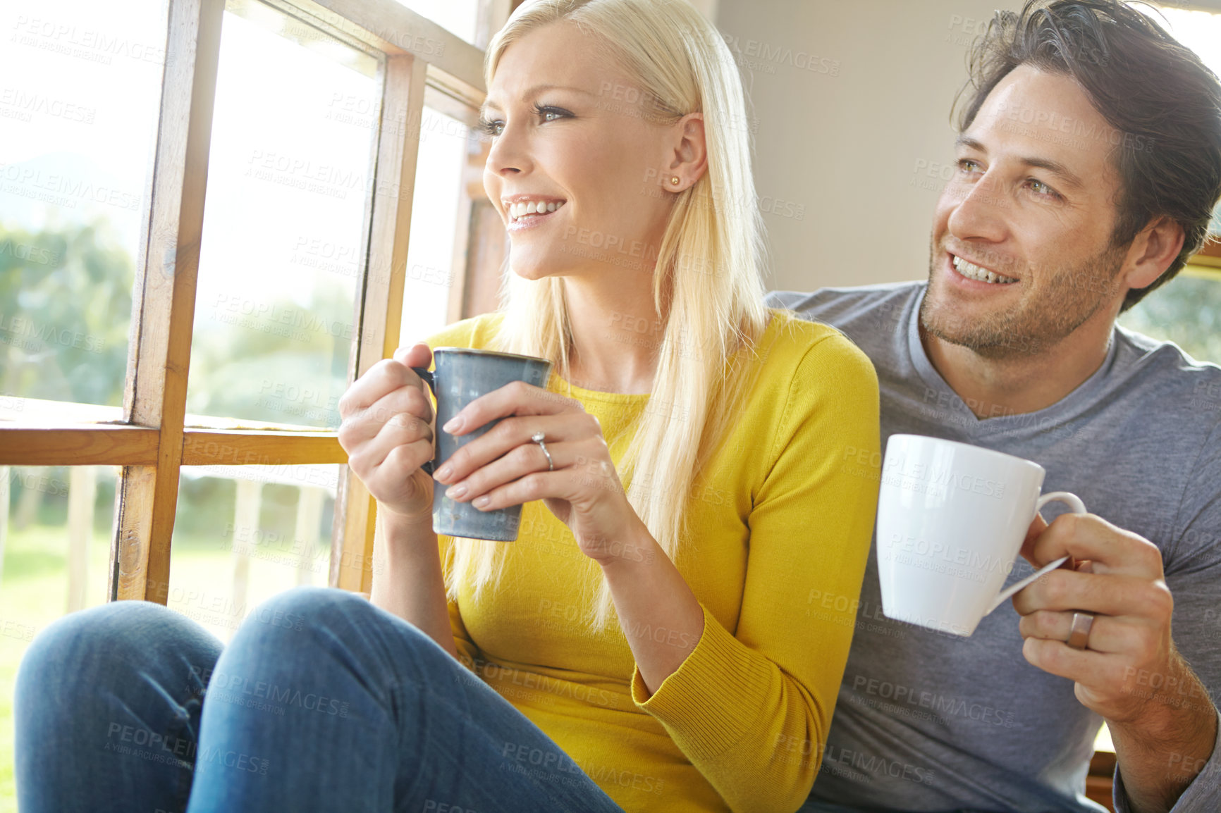 Buy stock photo Happy couple, window and thinking with coffee for morning, holiday or weekend together at home. Young man and woman with smile in relax for drink, hot beverage or cappuccino in living room at house