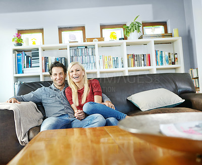 Buy stock photo Portrait of a young couple sitting on a couch together