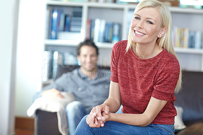 Buy stock photo Portrait of an attractive young woman in a living room with her boyfriend in the background