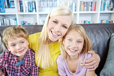 Buy stock photo Portrait of happy mother sitting on the sofa with her son and daughter