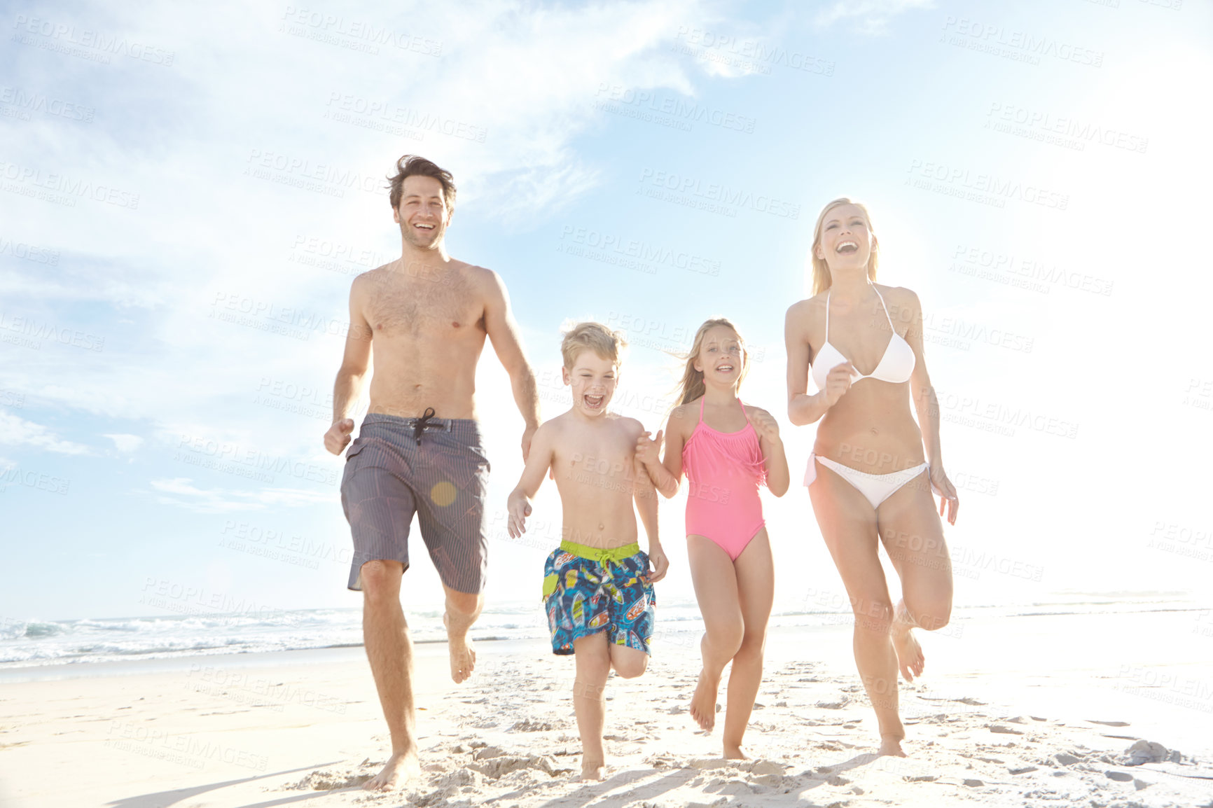 Buy stock photo Happy, family and running outdoor at beach for freedom, fun and relax on summer holiday in Bali. Excited, children and parents with smile for bonding and playing in sand on vacation to Indonesia