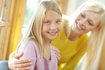 Buy stock photo Portrait of a mother and daughter sitting beside a window on a sunny day