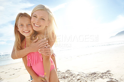 Buy stock photo Portrait of a mother and daughter embracing on a beach