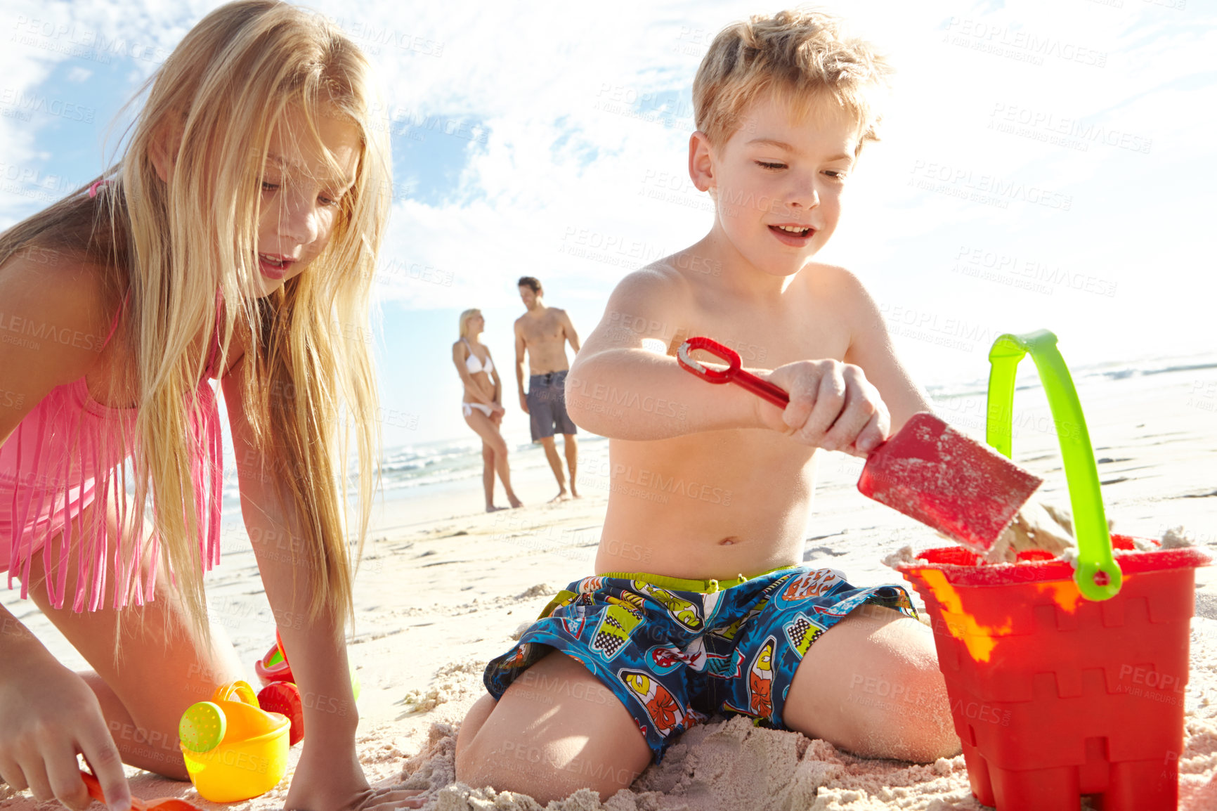 Buy stock photo Children, sand and toys at beach for vacation, adventure and travel for family holiday in summer. Boy, girl and bucket in nature with smile, energy and development in Bali for sunshine by ocean