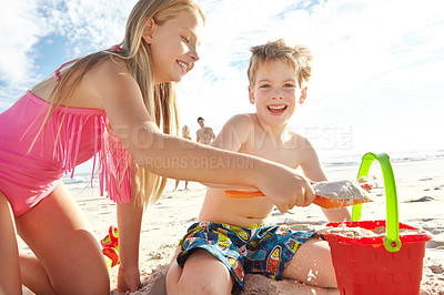 Buy stock photo Children, beach and bucket by ocean for sand castle, fun and bonding together in nature. Siblings, happy and family in sunshine for development, holiday and creative on seashore in summer vacation