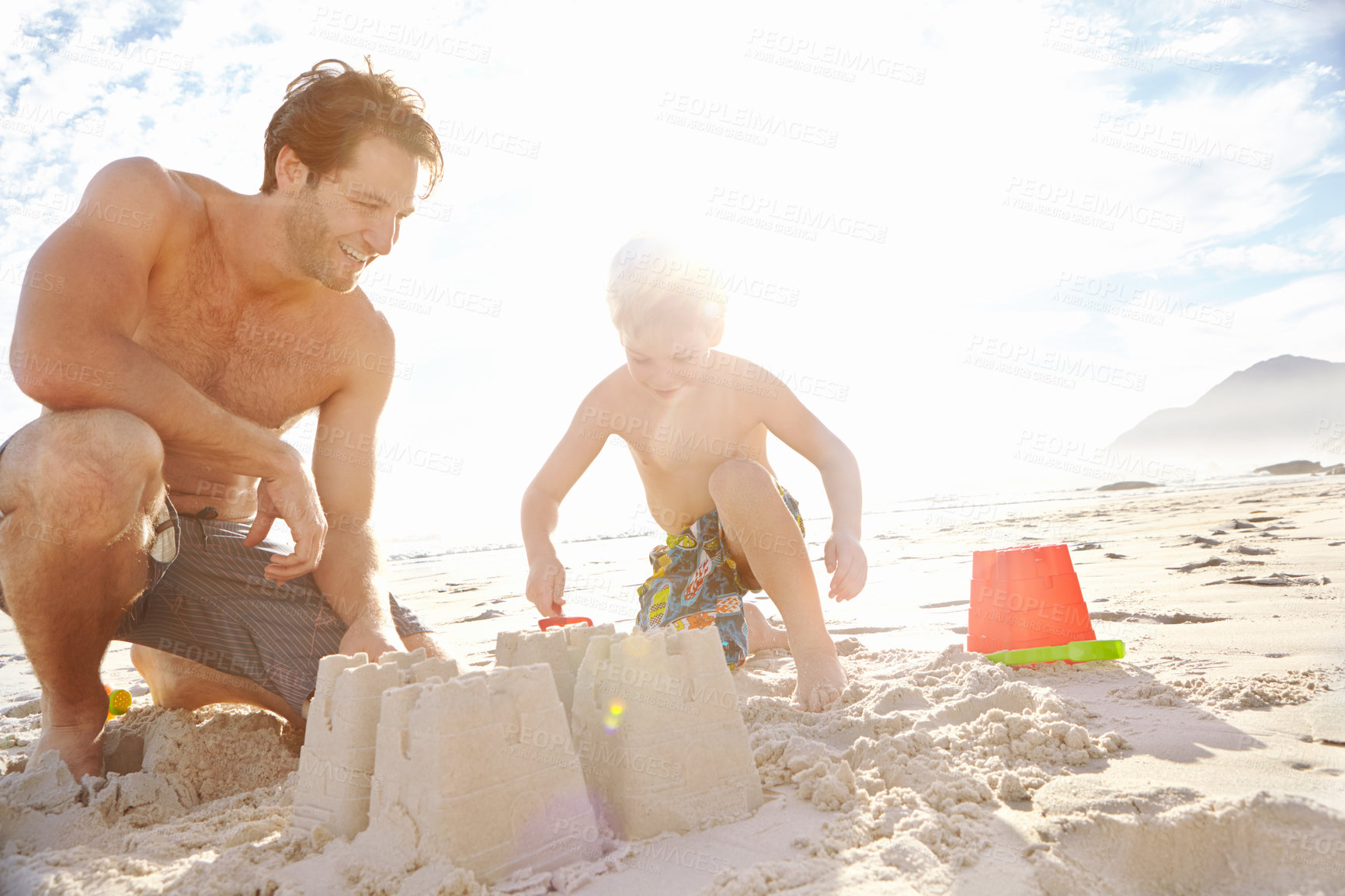 Buy stock photo Father, son or building with sand castle and smile on beach for vacation, sunshine in nature. Male person, boy child or holiday with bucket by sea for learning and development, travel in Mauritius