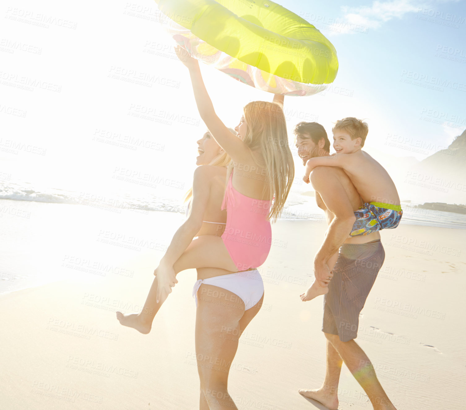 Buy stock photo Happy, family and children on back at beach together for bonding, relax and love for adventure in summer sunshine. Parents and kids playful on vacation, trust and support with ocean in Australia