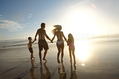 Buy stock photo Sunset, freedom and family holding hands at a beach for summer, fun and bonding in nature together. Travel, care and back of children with parents at sea for vacation, journey or tropical adventure