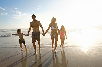 Buy stock photo Love, sky and sunset with family on beach, running together in summer for bonding or fun. Energy, happy or smile with mother, father and children on sand by ocean or sea for holiday and vacation