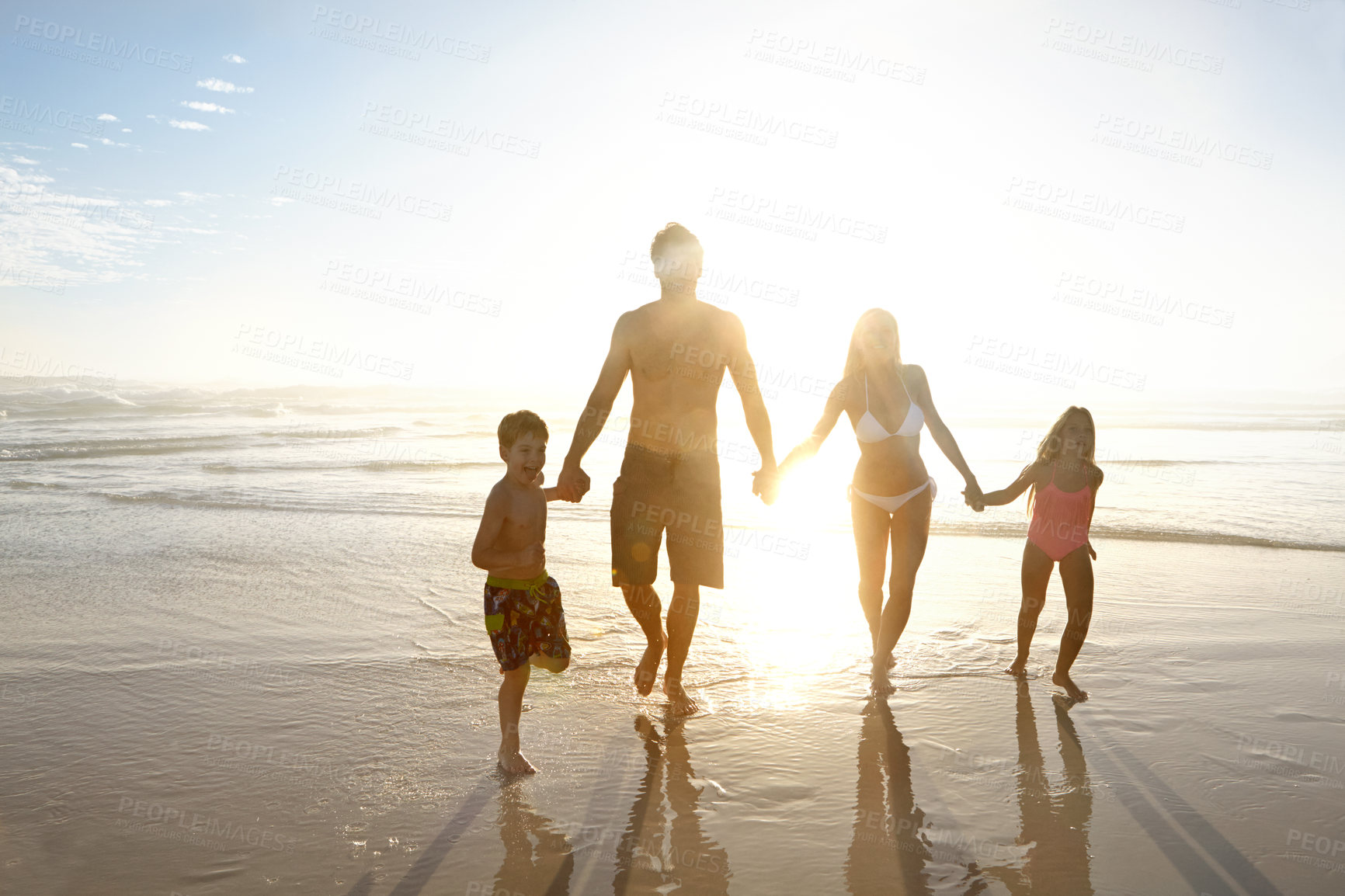 Buy stock photo Love, holiday hands and sunset with family on beach, running together on sky for bonding or fun. Happy, smile or summer with mom, dad and children on sand by ocean or sea for holiday and vacation