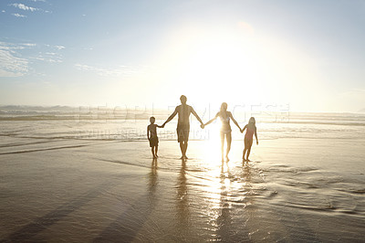 Buy stock photo Shot of a family walking on a beach at sunset