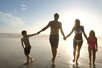 Buy stock photo People, holding hands and silhouette on beach in outdoors at sunset for vacation, holiday or getaway. Family, support and community by ocean on sand with love, care and children with parents by waves