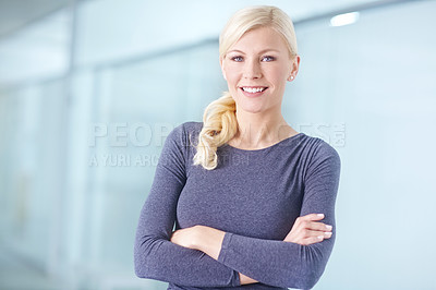 Buy stock photo Portrait of a business woman standing with folded arms inside an office. Happy and confident female employee or boss in modern workspace. Young successful professional worker