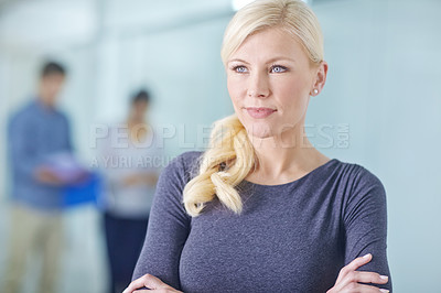 Buy stock photo Attractive young blonde woman daydreaming and standing with her arms crossed in an office. One proud female businessperson thinking at work. Expert business professional smiling while standing at work