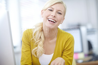 Buy stock photo Shot of an attractive young office worker laughing while sitting at her desk in an office