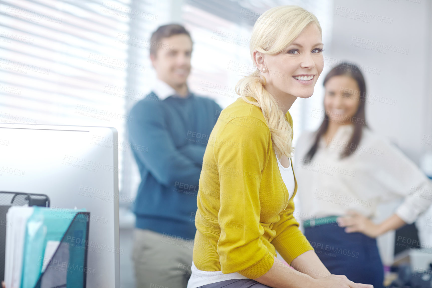 Buy stock photo Portrait of an attractive young blonde businesswoman with her colleagues in the background