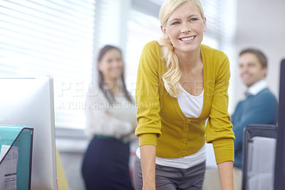 Buy stock photo Portrait of an attractive young blonde businesswoman with her colleagues in the background