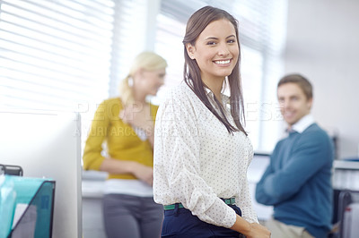 Buy stock photo Portrait of an attractive young brunette businesswoman with her colleagues in the background