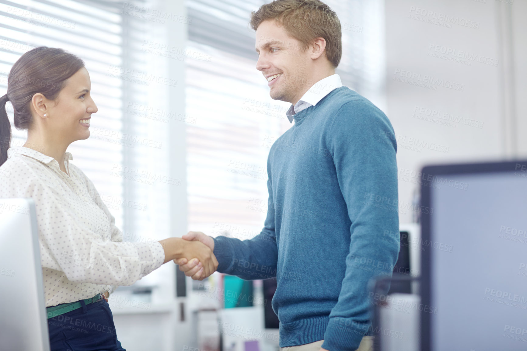 Buy stock photo Cropped shot of two young coworkers shaking hands