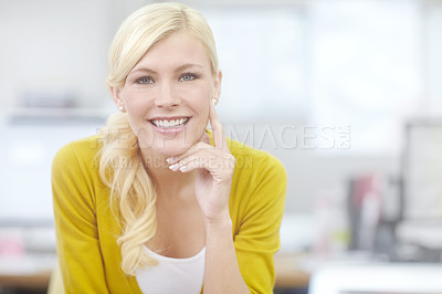 Buy stock photo Portrait of a beautiful young blonde woman sitting in an office. One cheerful female businessperson at work. Business professional smiling at her workplace alone. Woman working at a startup company