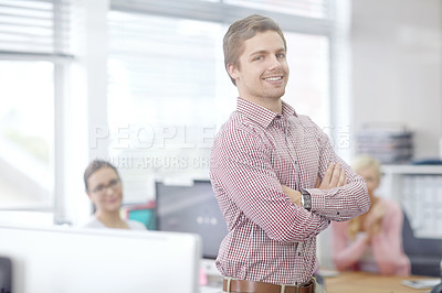 Buy stock photo Portrait of a handsome young businessman with his colleagues in the background
