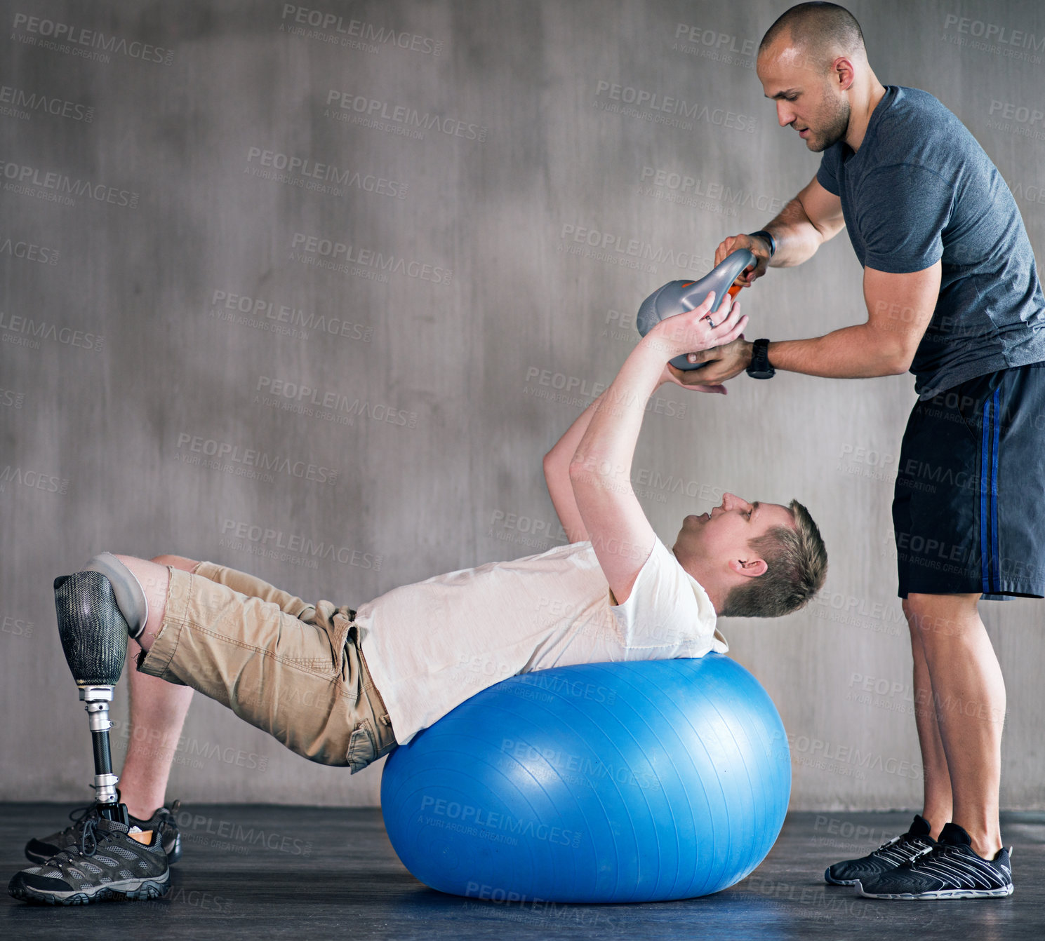 Buy stock photo Physiotherapist, person with a disability and prosthetic leg and dumbbell in physiotherapy, studio and gym ball. Male people, trainer and amputee for wellness, fitness and exercise in workout session