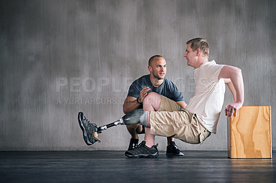 Buy stock photo Trainer, person with a disability and prosthetic leg and dumbbell in physiotherapy, studio and gym ball. Male people, physiotherapist and amputee for wellness, fitness and exercise in sports center
