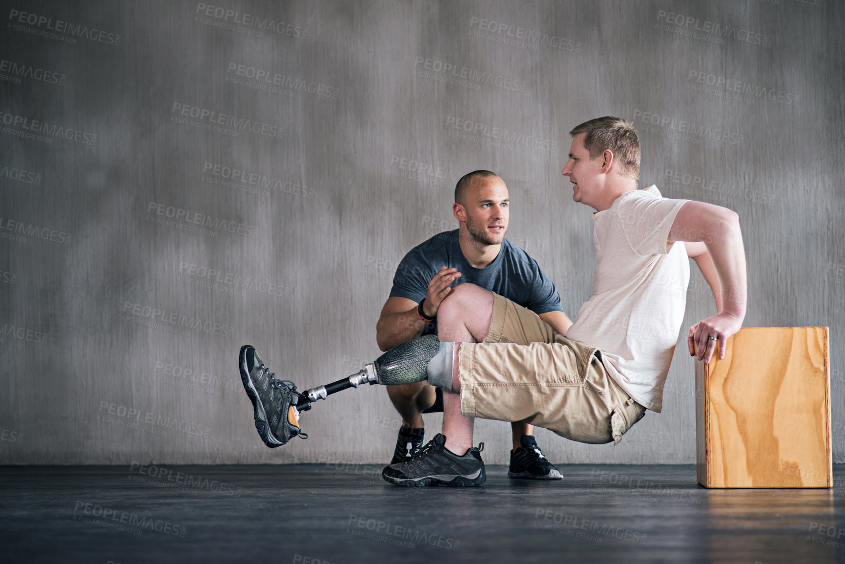 Buy stock photo Trainer, person with a disability and prosthetic leg and dumbbell in physiotherapy, studio and gym ball. Male people, physiotherapist and amputee for wellness, fitness and exercise in sports center
