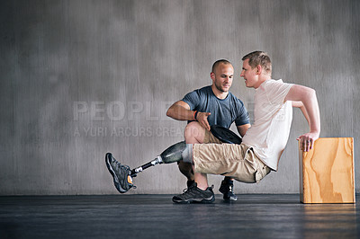 Buy stock photo Shot of a physiotherapist helping a young male amputee workout