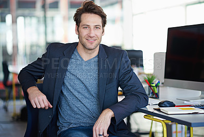 Buy stock photo Portrait of a handsome designer sitting at his workstation in an office