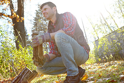 Buy stock photo Man, forest and collect wood for fire or survival with camp for adventure and explore in Canada. Male person, outdoor and smile or happy with firewood in nature for warmth on campsite and countryside