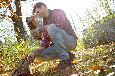 Buy stock photo Man, forest and happy with wood for fire or survival with camping for adventure and explore in Canada. Male person, outdoor and smile with firewood in nature for warmth on campsite and countryside