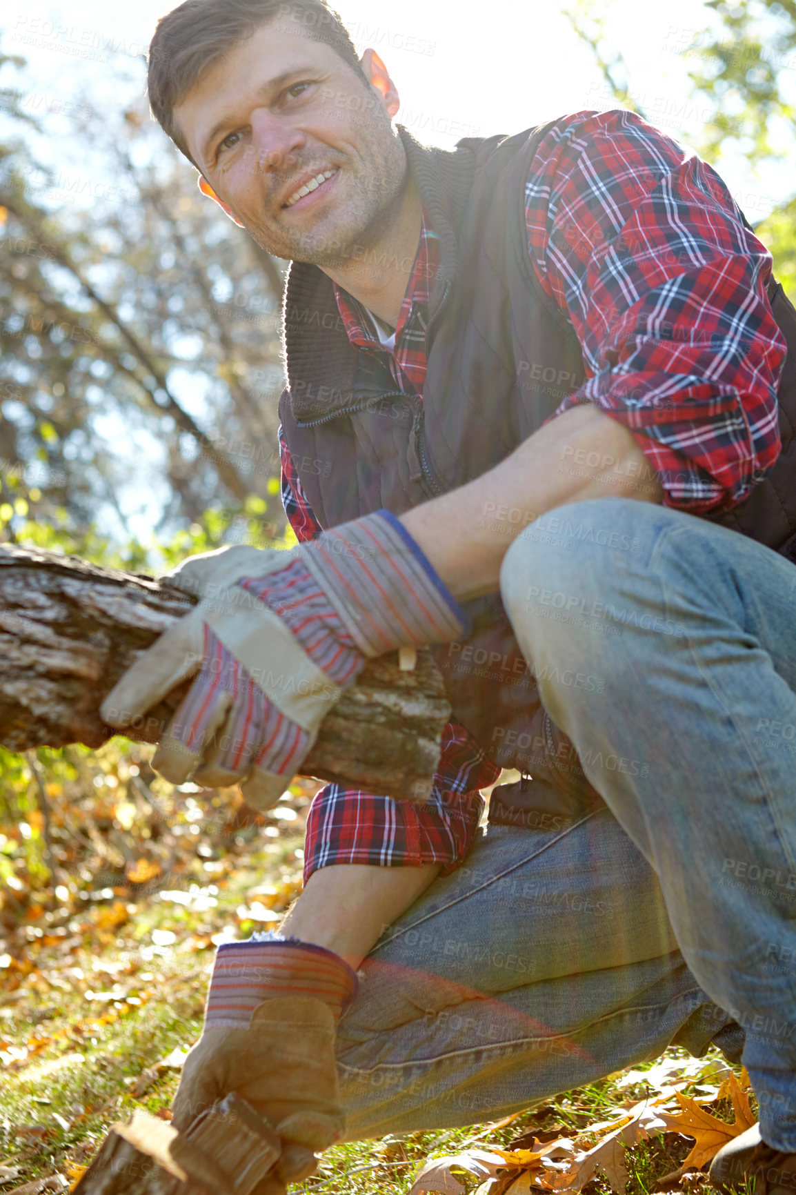 Buy stock photo Man, wood and lumberjack in forest outdoor for deforestation, tree cutting and process of harvesting impact. Smile, male person and timber extraction, environment and resource of fireplace solution