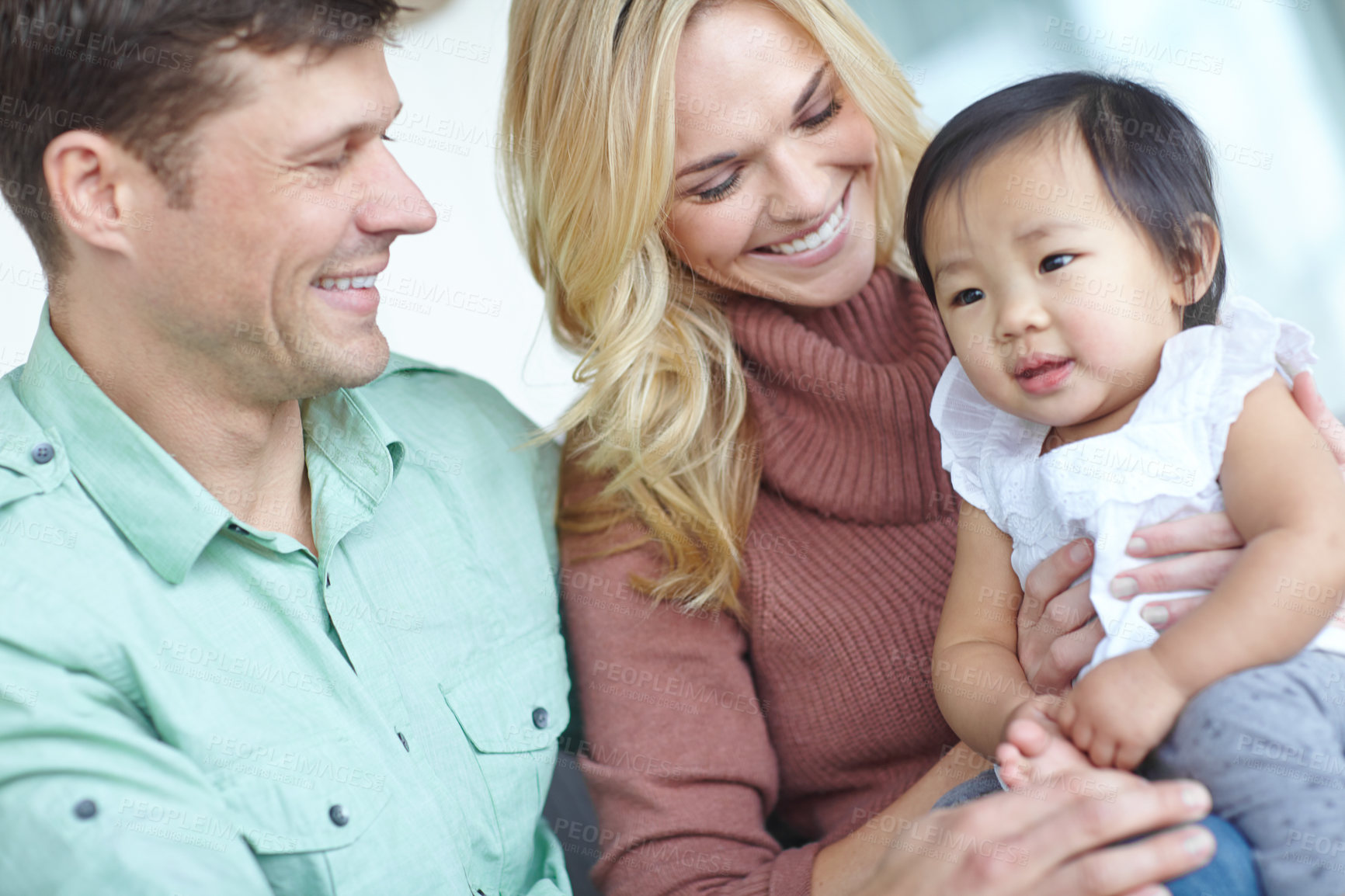 Buy stock photo Happy family, parents and adopted baby in home for custody, support and bonding together. Mother, kid and father with cute foster child for connection, orphan and interracial care with toddler