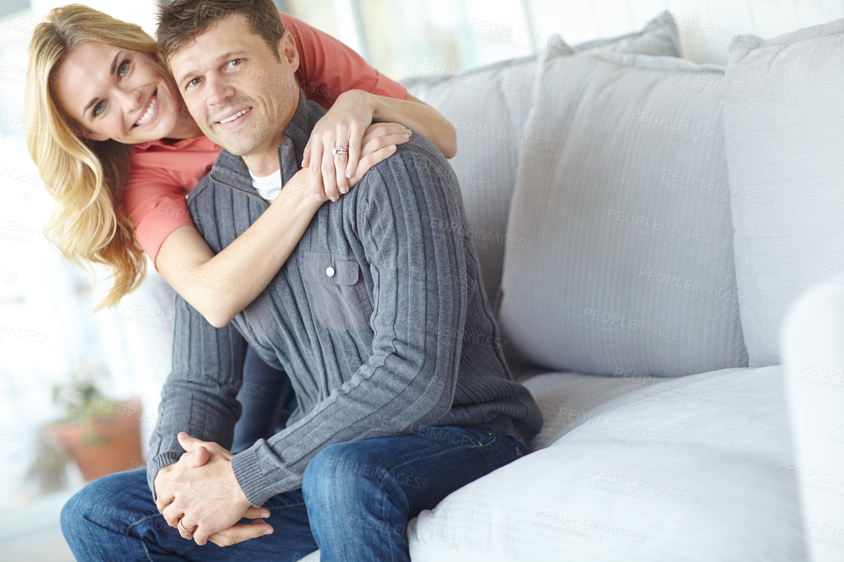 Buy stock photo Portrait, hug and happy couple in home for relax, love and loyalty together in lounge. Smile, man and woman embrace on sofa for support, connection and care for relationship commitment with partner