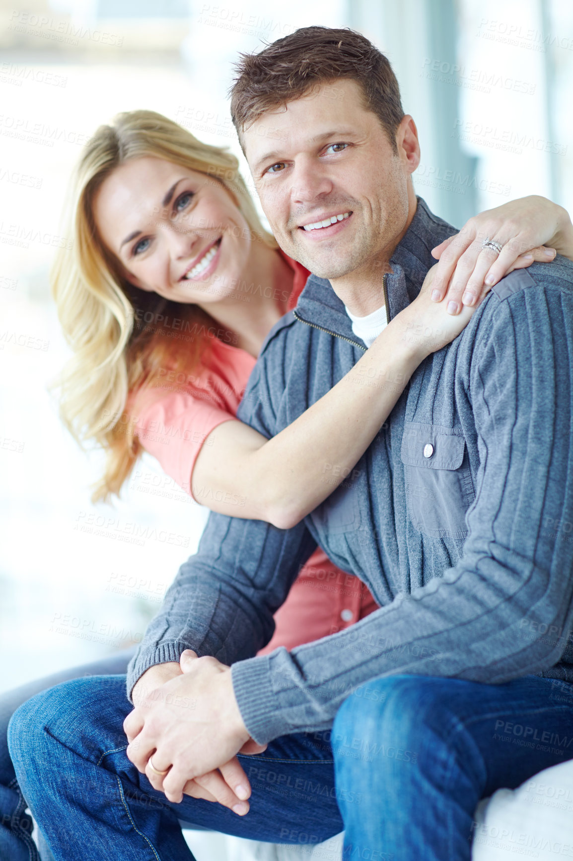 Buy stock photo Portrait, hug and happy couple on sofa for love, relax and loyalty together in lounge. Smile, man and woman embrace in home for support, connection and care for relationship commitment with partner